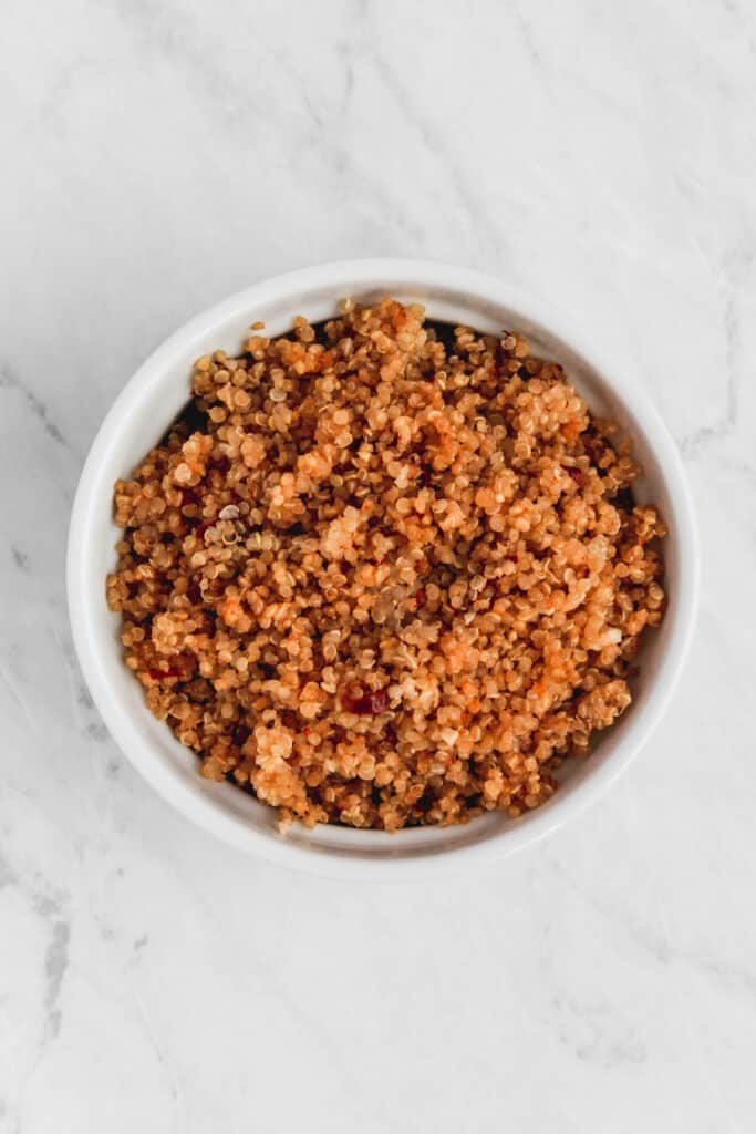 Garlic chipotle quinoa served in a white dish on a marble background