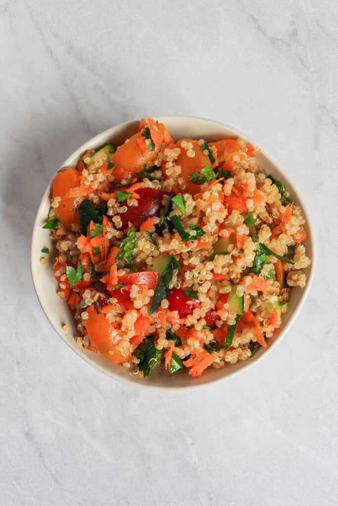 A single serving bowl of the colorful Tabbouleh salad on a marble background